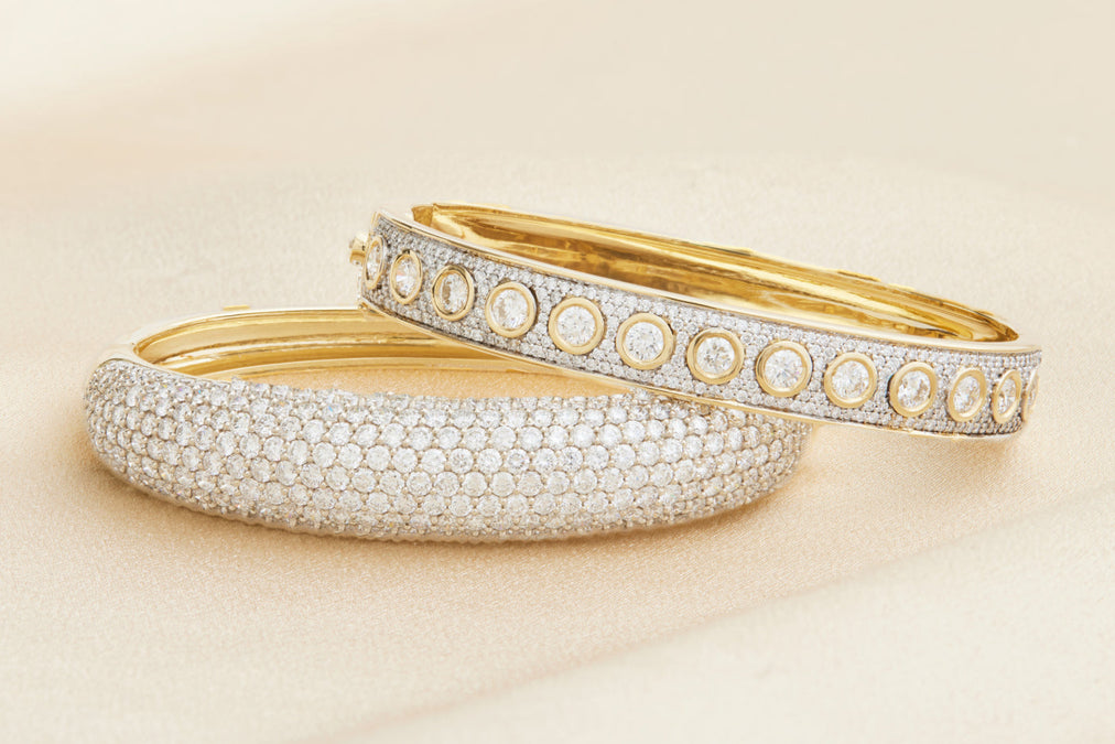 Two gold and silver bangles on a beige background